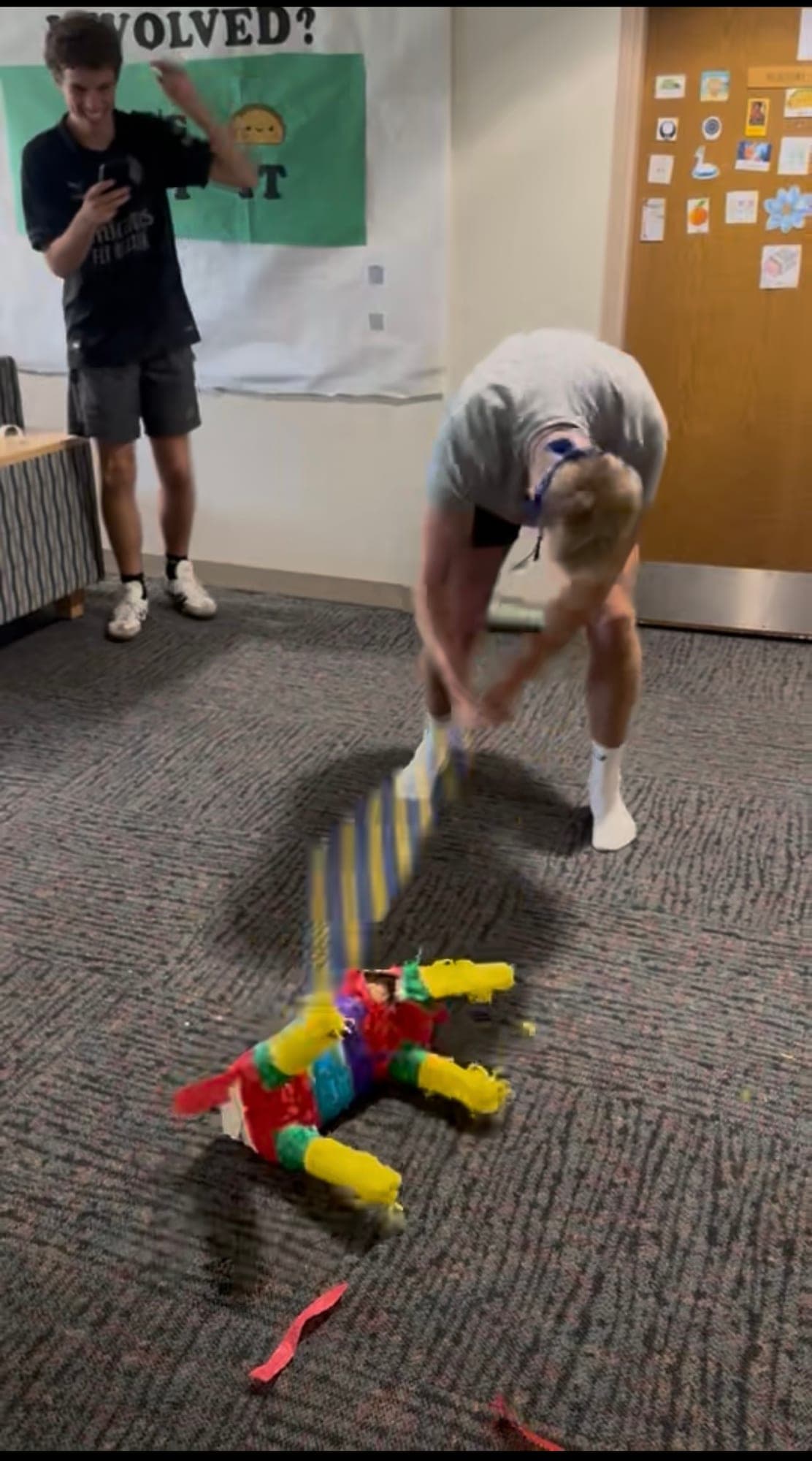 Me mid-swing at a piñata, blindfolded, with people watching.