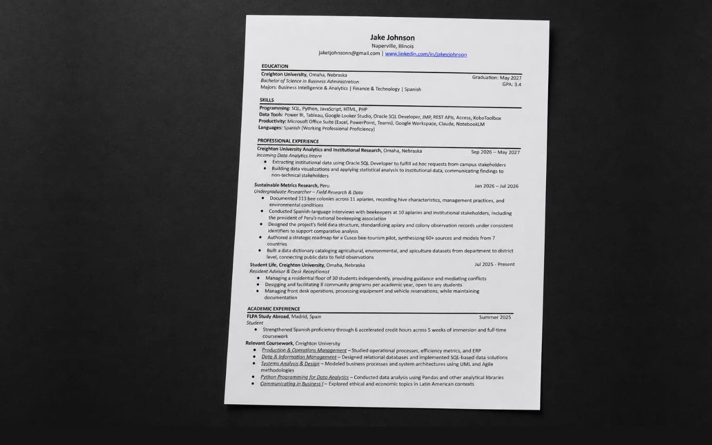 A printed résumé lying on a dark desk surface, photographed at a slight angle.